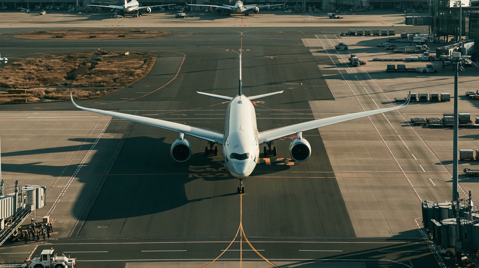 Aerial view of an airliner taxiing toward the gates across the apron