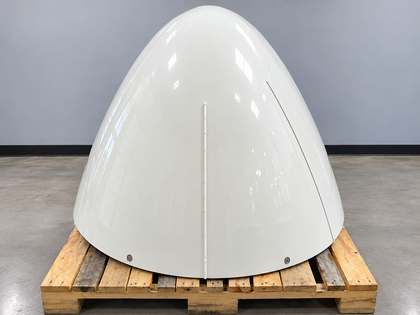 White aircraft radome on a wooden pallet
