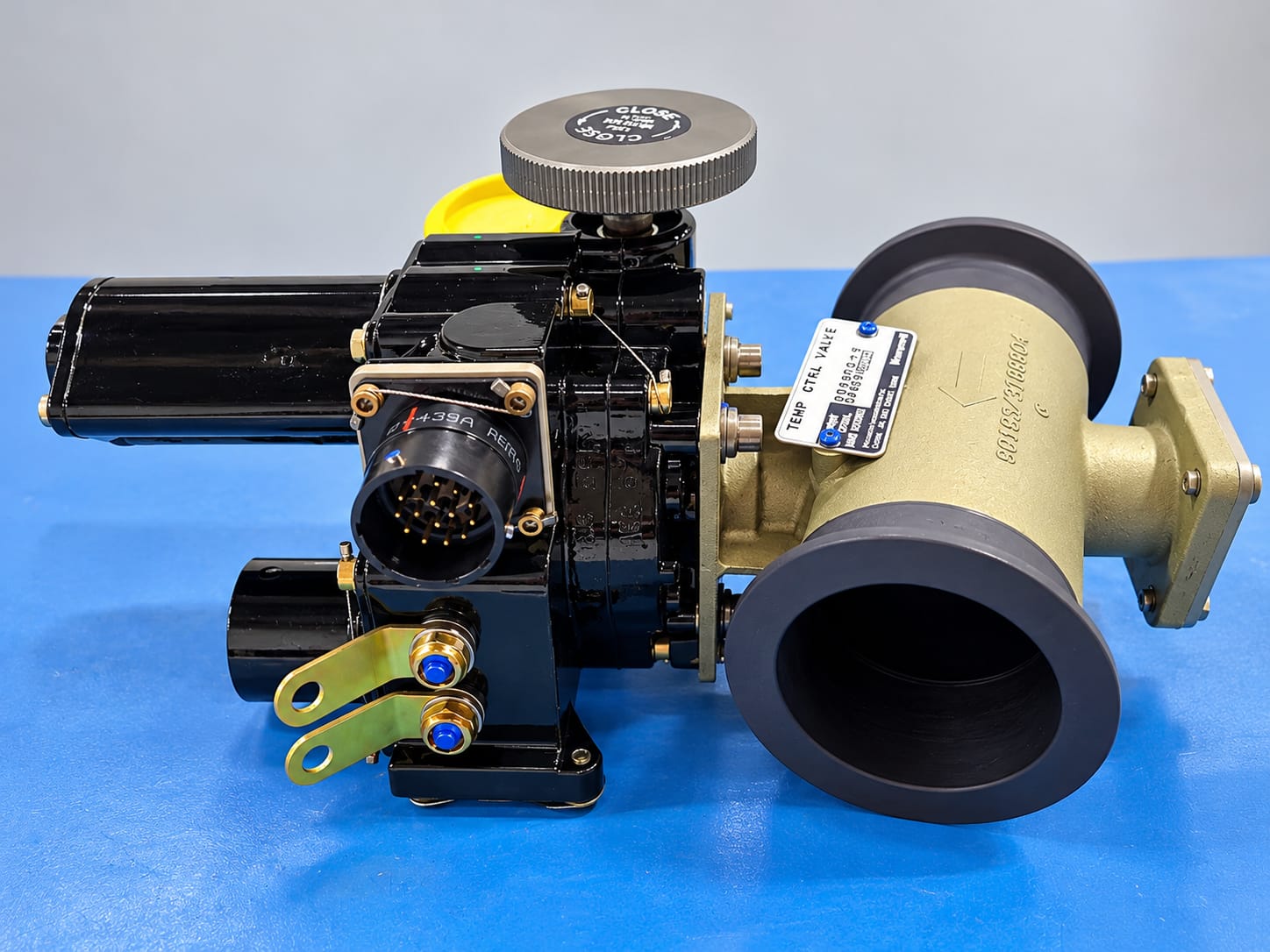 Aircraft valve actuator assembly with electrical connector on a blue workbench